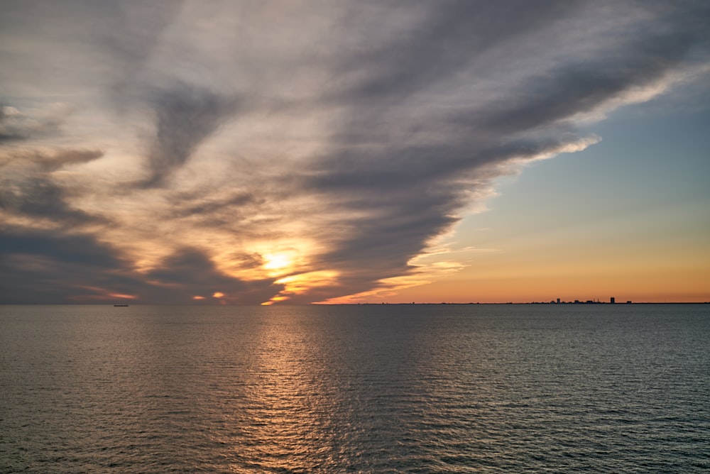 a large body of water under a cloudy sky