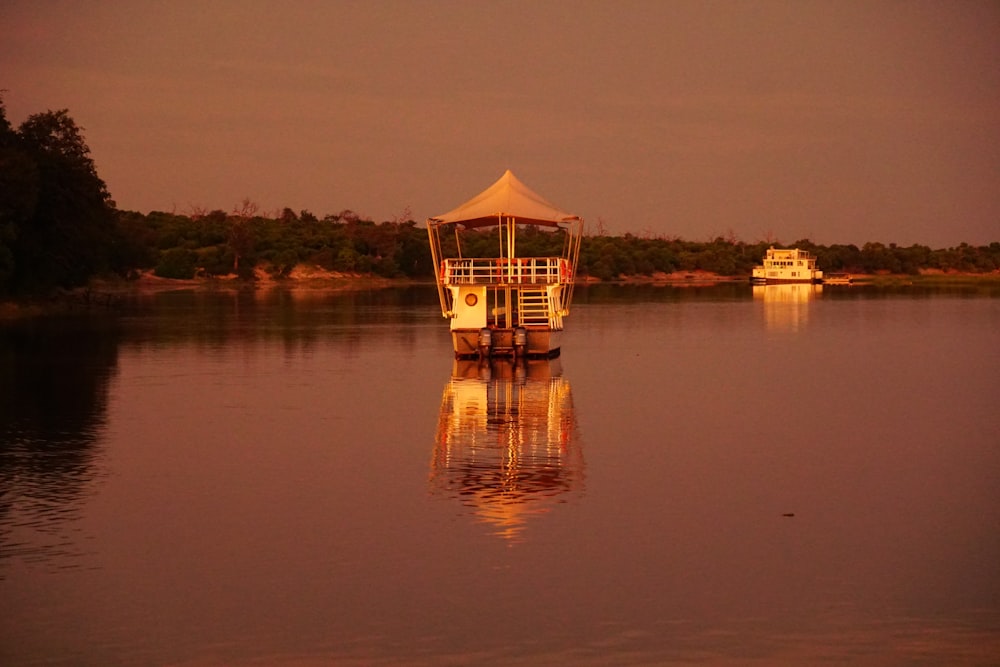 a boat floating on top of a lake next to a forest