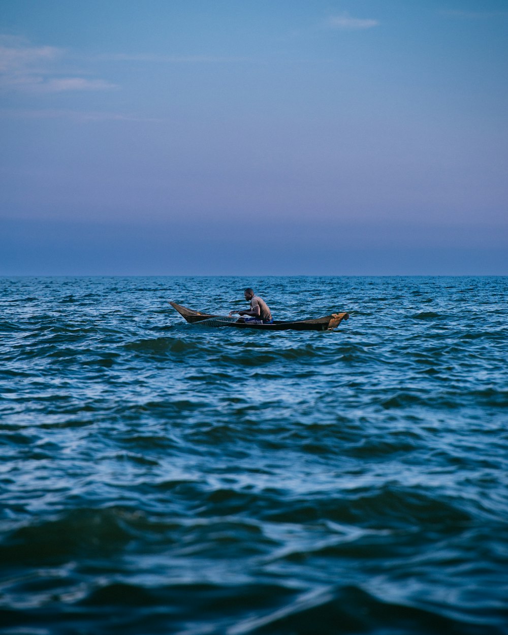a man in a boat in the middle of the ocean