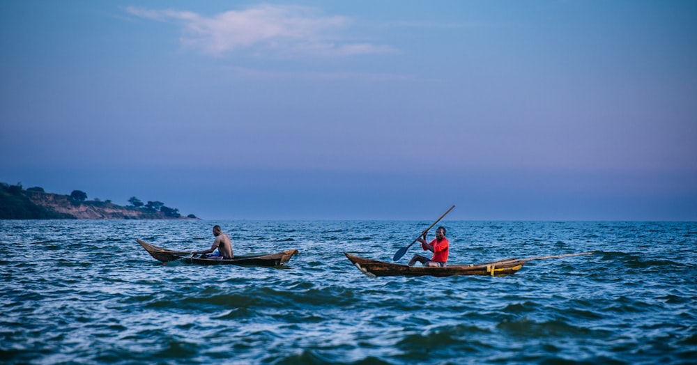 two people in small boats on the water