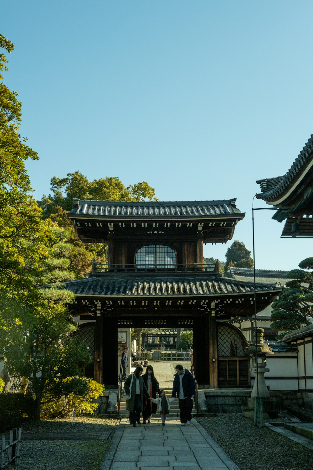 a group of people walking down a walkway in front of a building