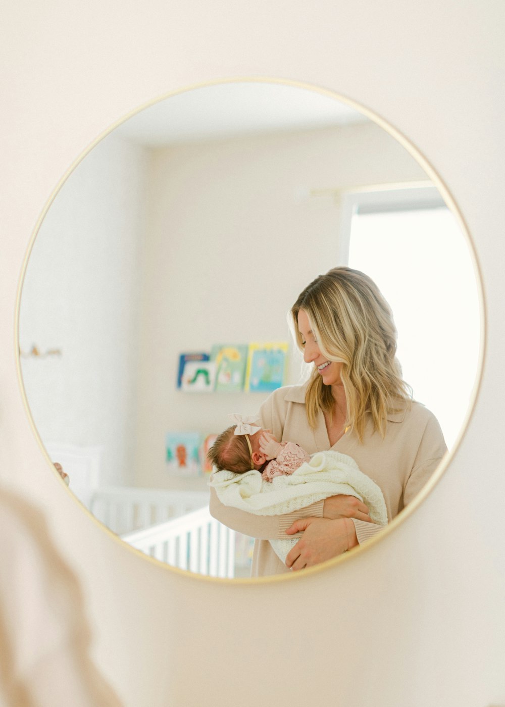 a woman holding a baby in her arms in front of a mirror