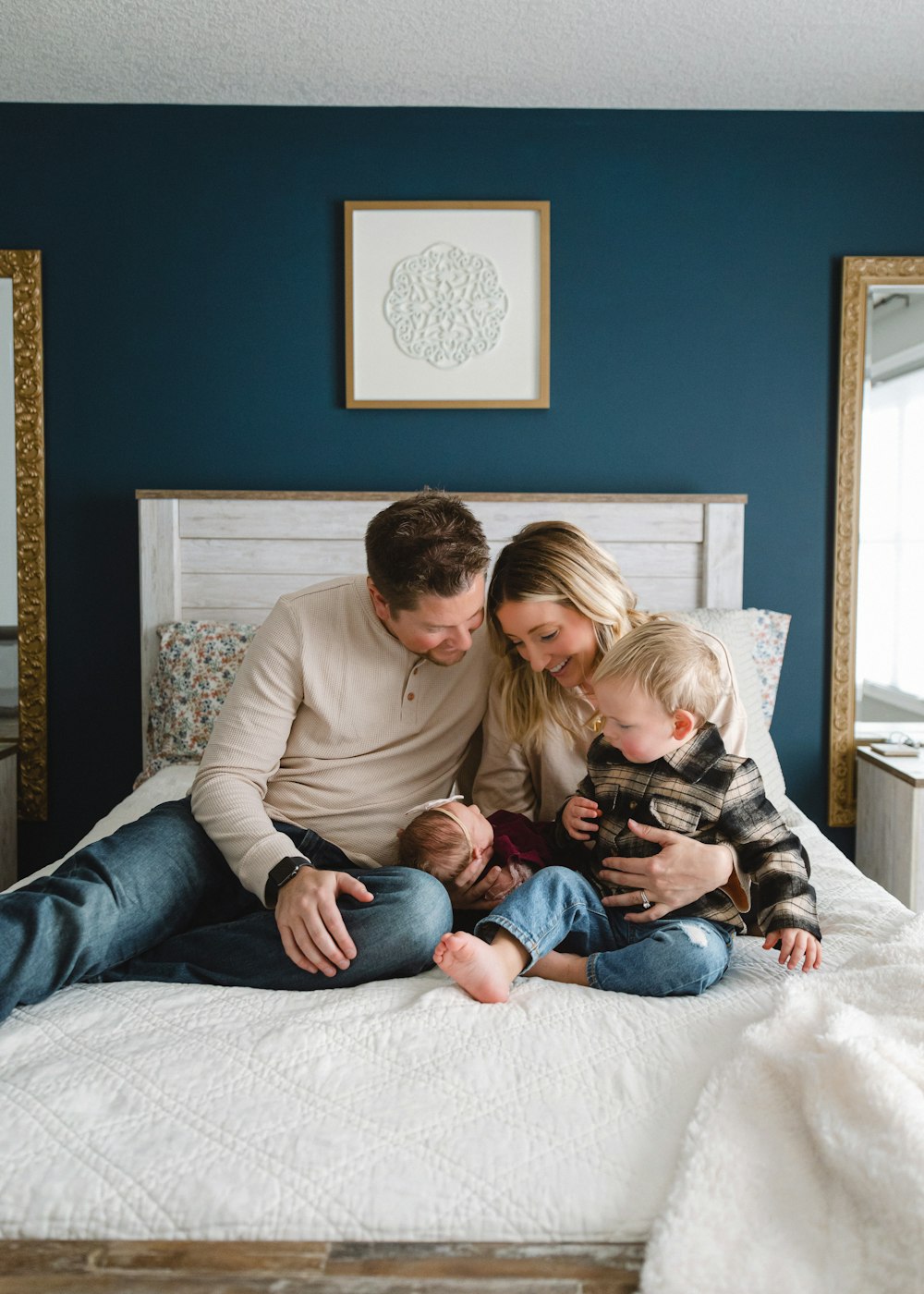 a man, woman, and child sitting on a bed