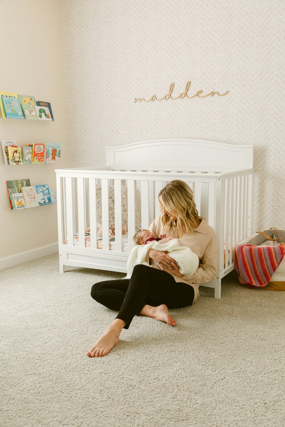 a woman sitting on the floor with a baby in her lap