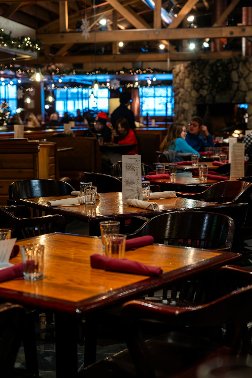 a restaurant filled with wooden tables and chairs