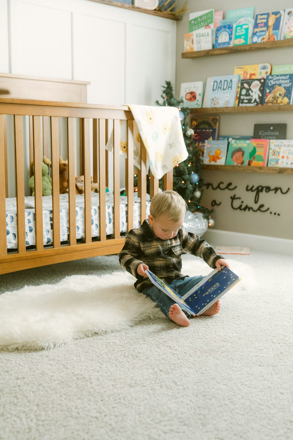 a young boy sitting on the floor reading a book