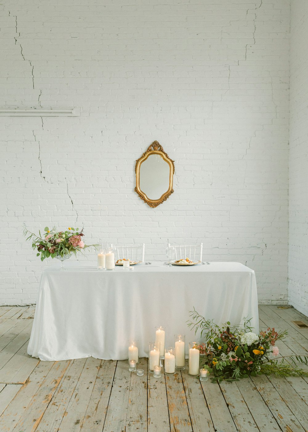 a white table with candles and a mirror