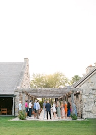 a group of people standing outside of a stone building