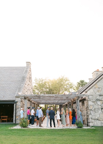 a group of people standing outside of a stone building