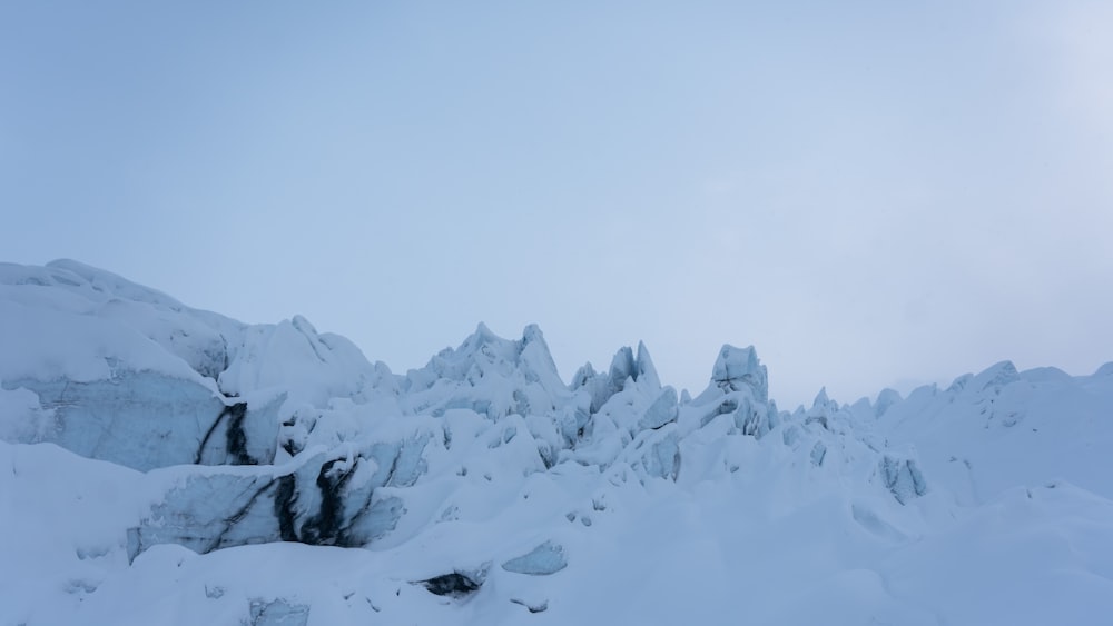 a mountain covered in lots of snow with a sky background