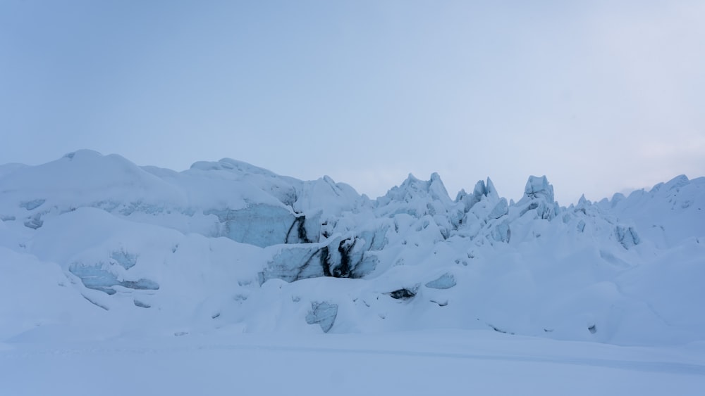 a mountain covered in lots of snow next to a forest