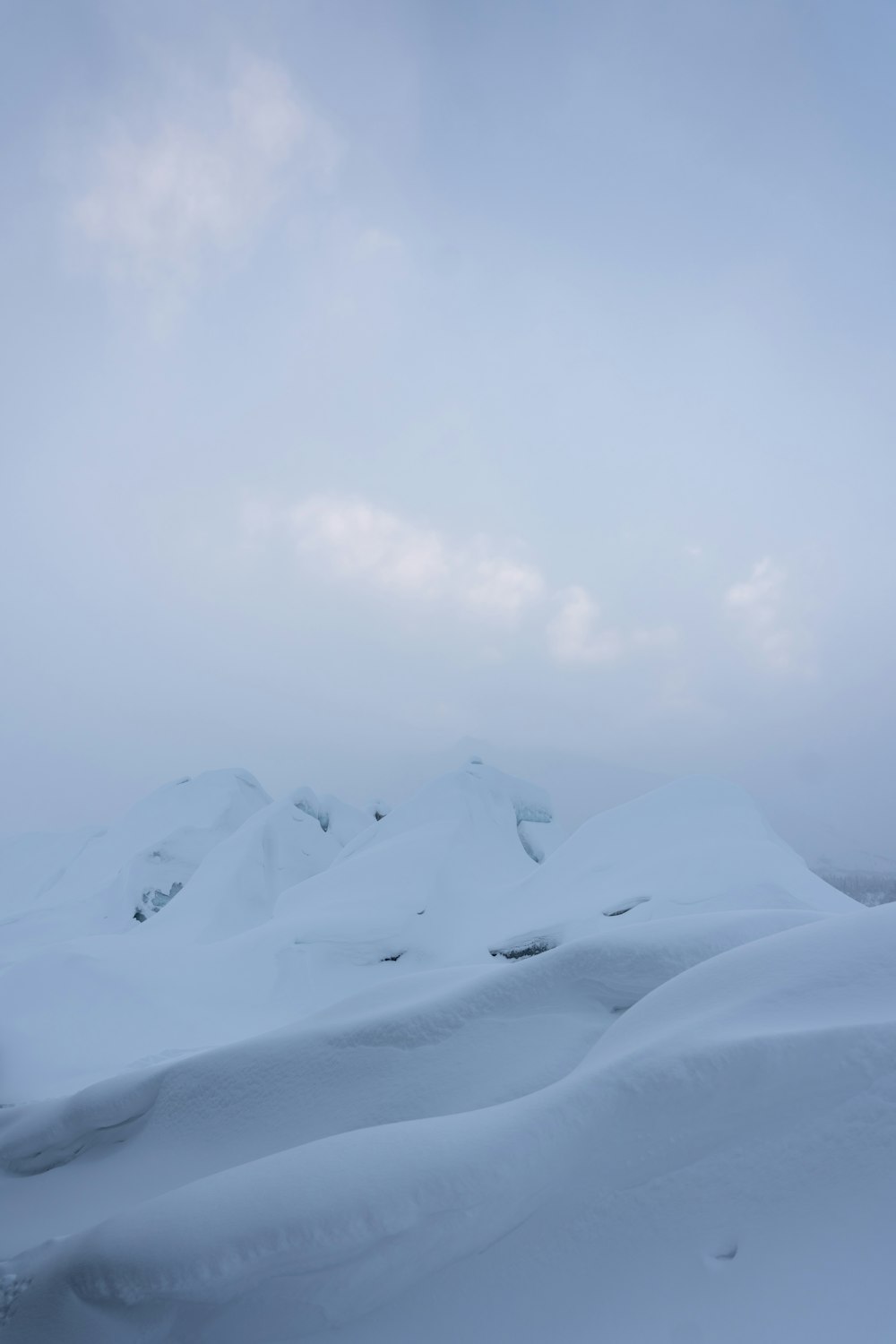 a mountain covered in snow under a cloudy sky