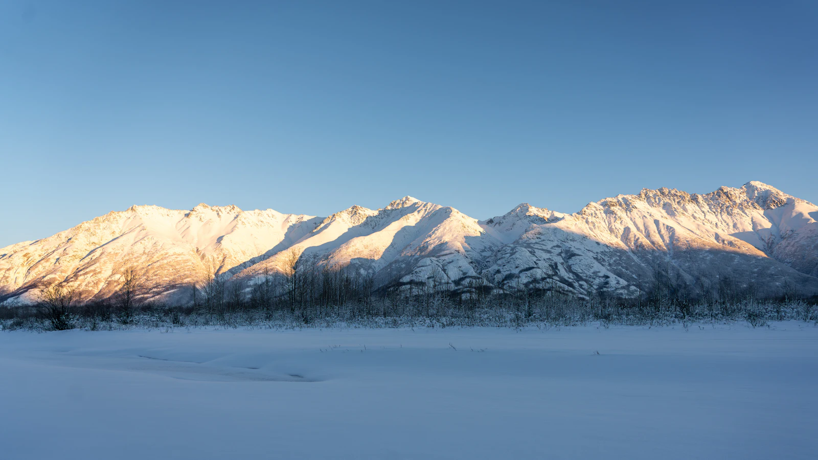Snow-covered Chugach Mountains rising above the water near Anchorage