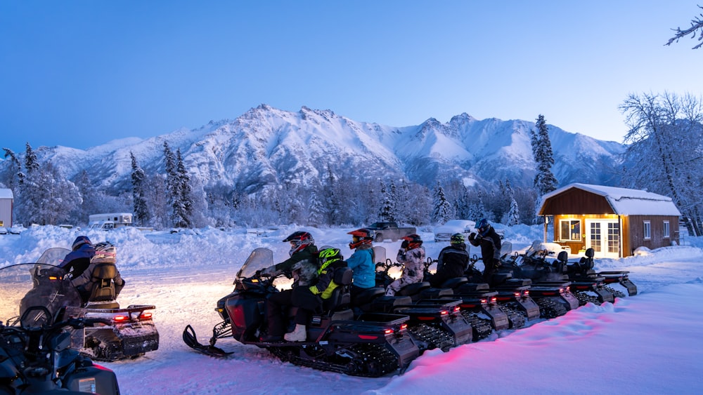 a group of people riding snowmobiles in the snow
