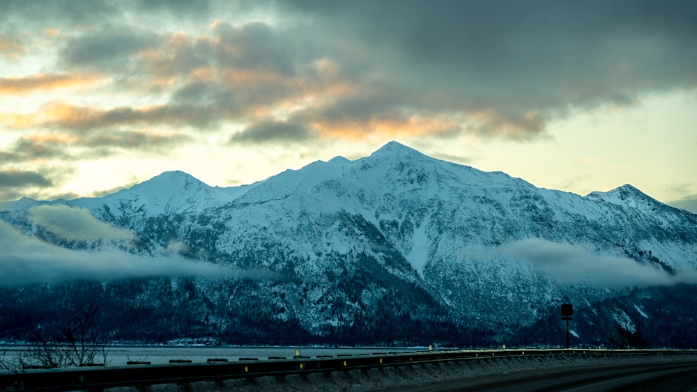 a snow covered mountain with a cloudy sky