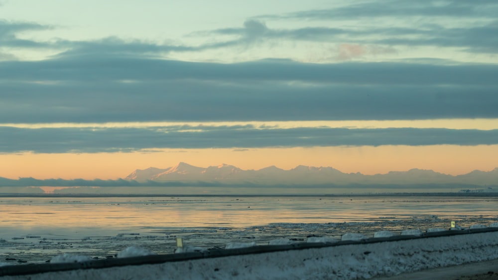 a large body of water with mountains in the background