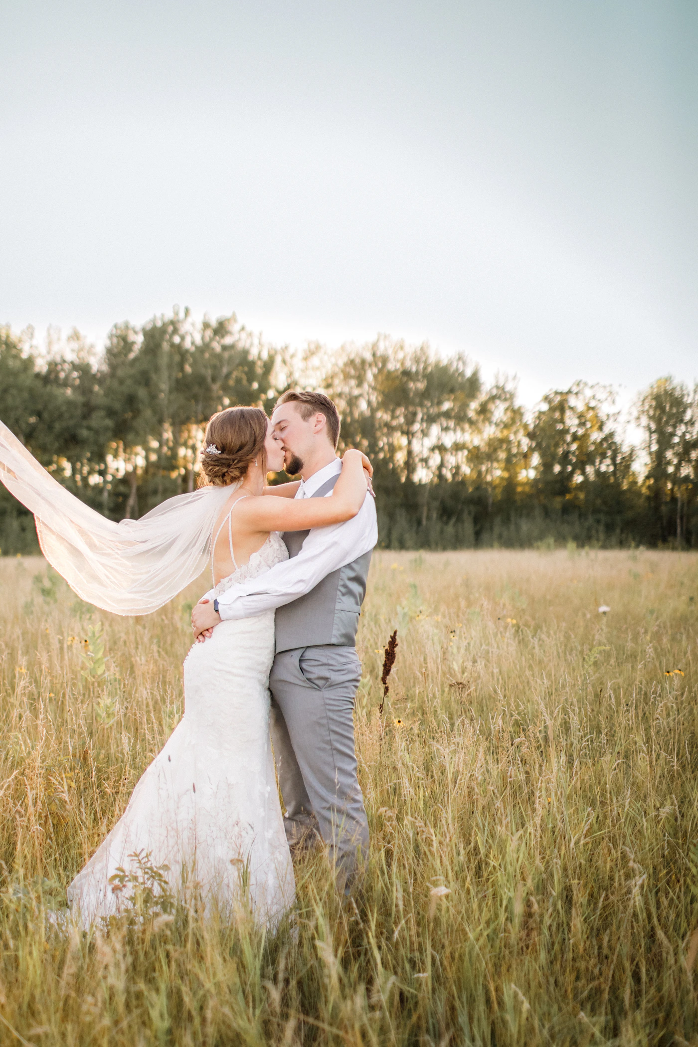 Elopement bouquet with white flowers and greenery hanging on a rustic brown wooden board altar decoration at outdoor ceremony venue