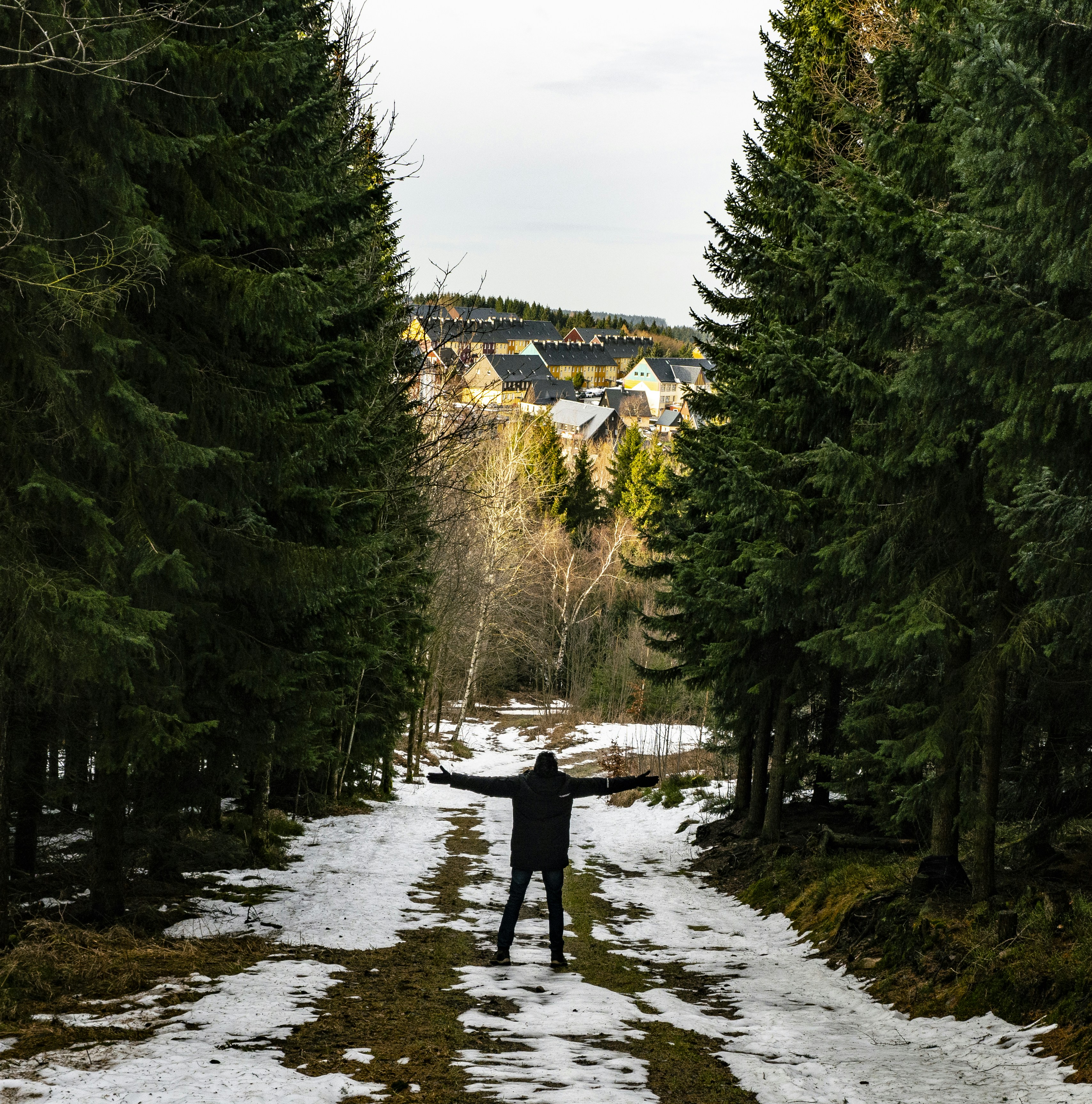 ein Mann, der mitten auf einer schneebedeckten Straße steht
