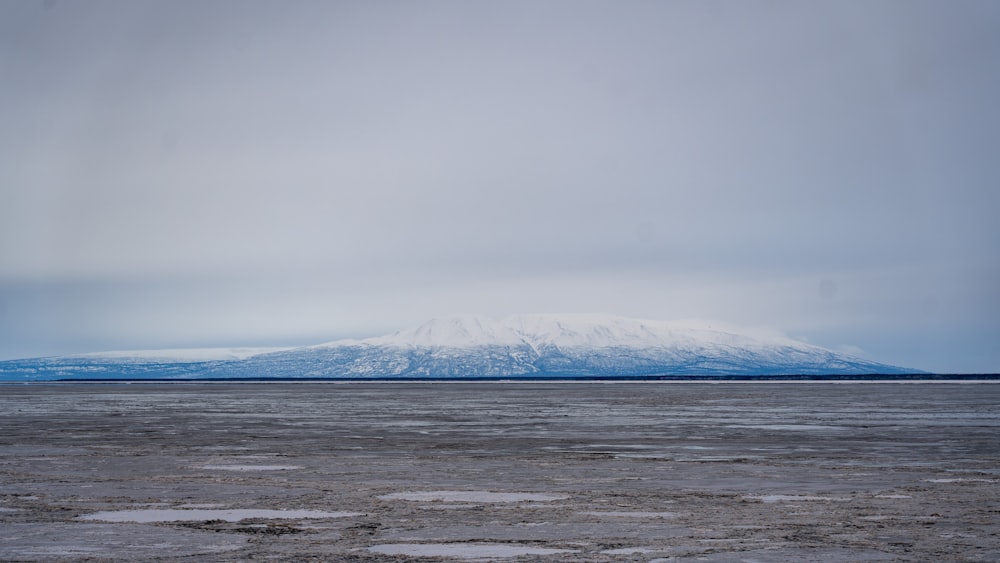 a large body of water with a mountain in the background