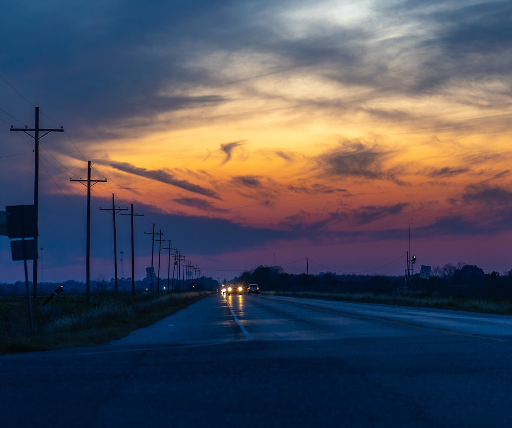 um carro dirigindo por uma estrada ao entardecer