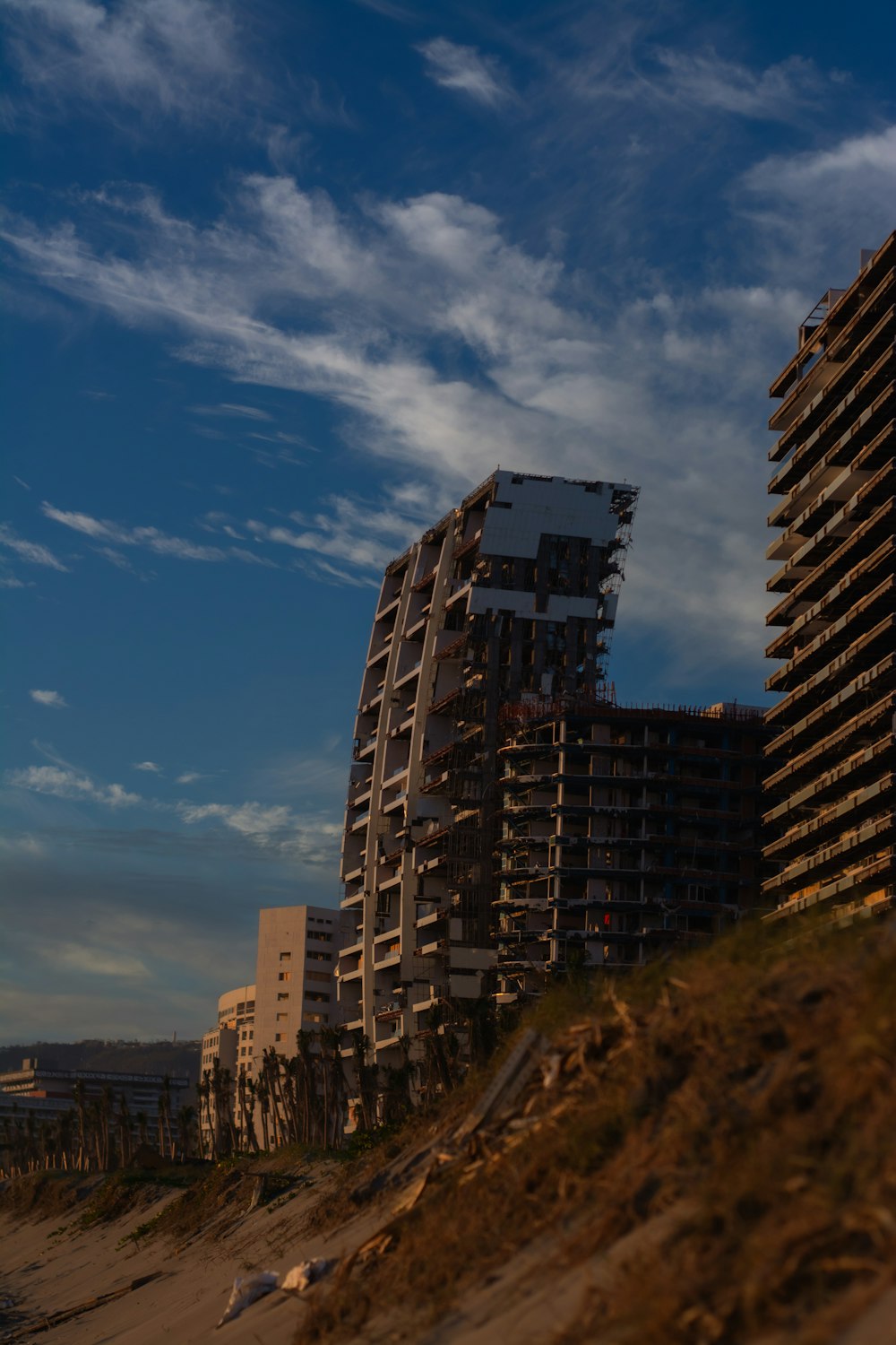 a couple of tall buildings sitting on top of a sandy beach