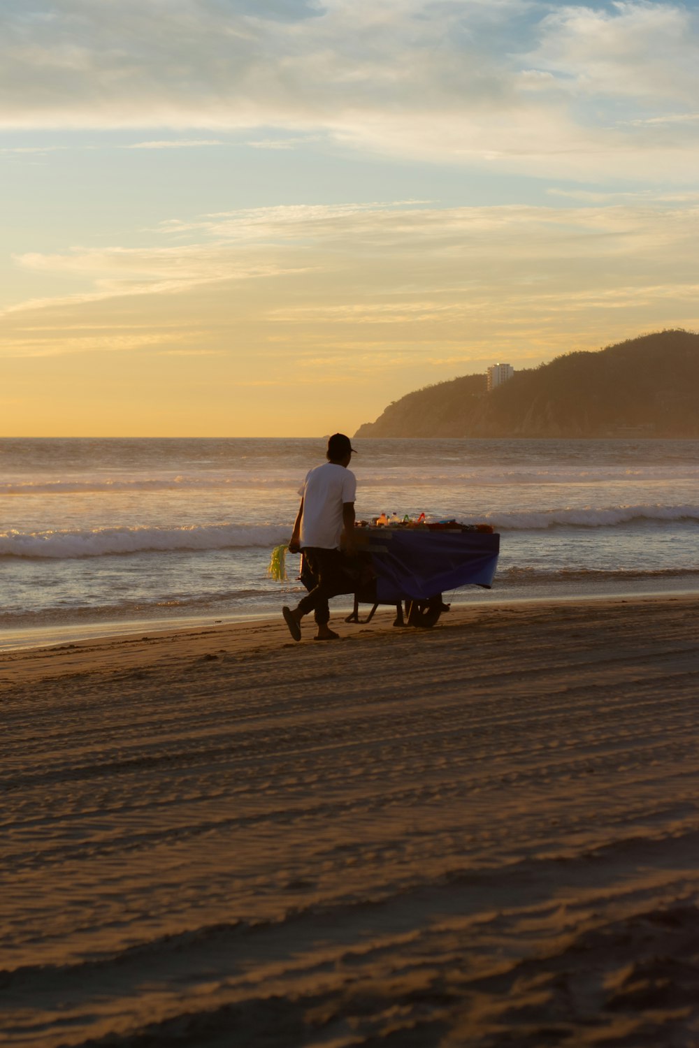 a man walking along a beach next to the ocean