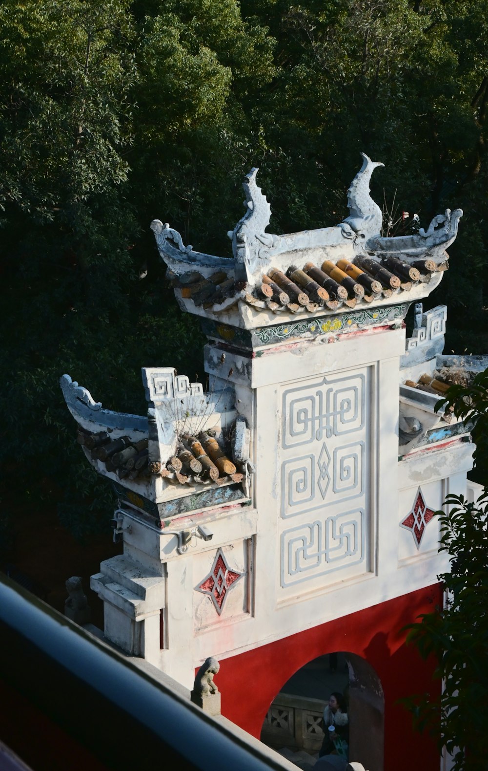 a tall white building with a red and white roof