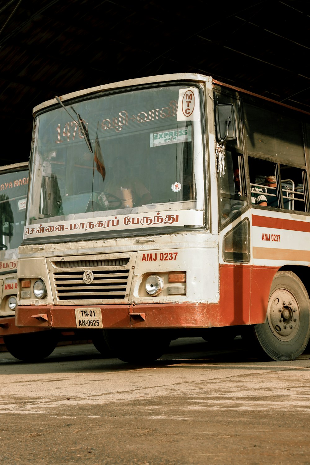 a red and white bus parked in front of a building