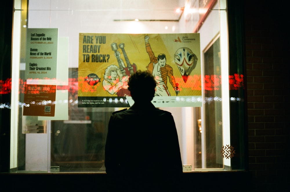 a man standing in front of a movie poster