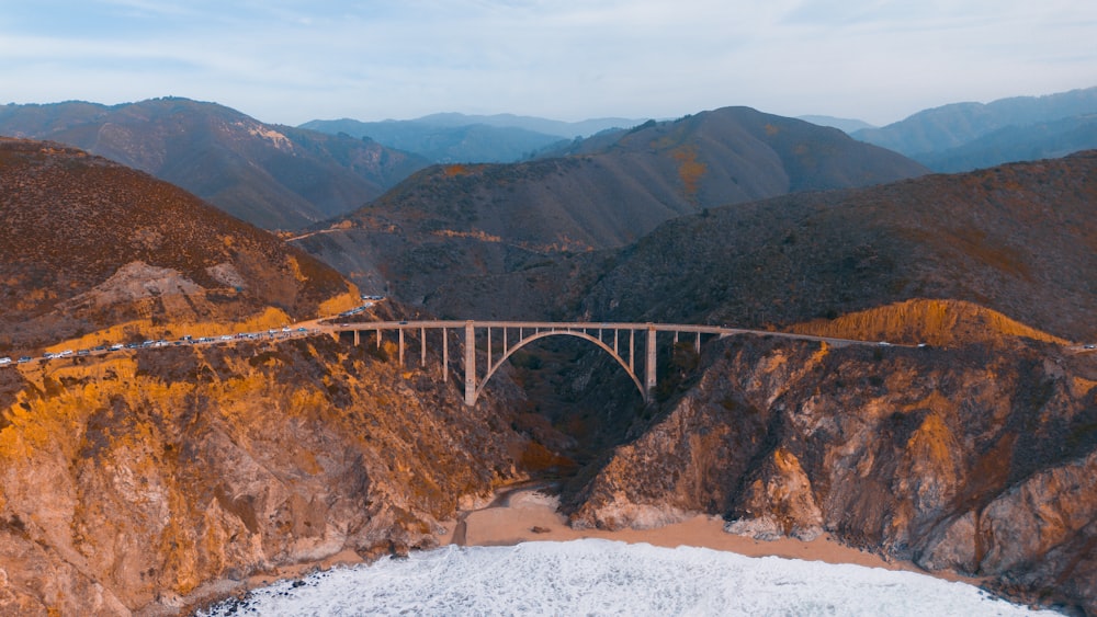 an aerial view of a bridge in the mountains