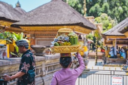 a woman carrying a basket of fruit on her head