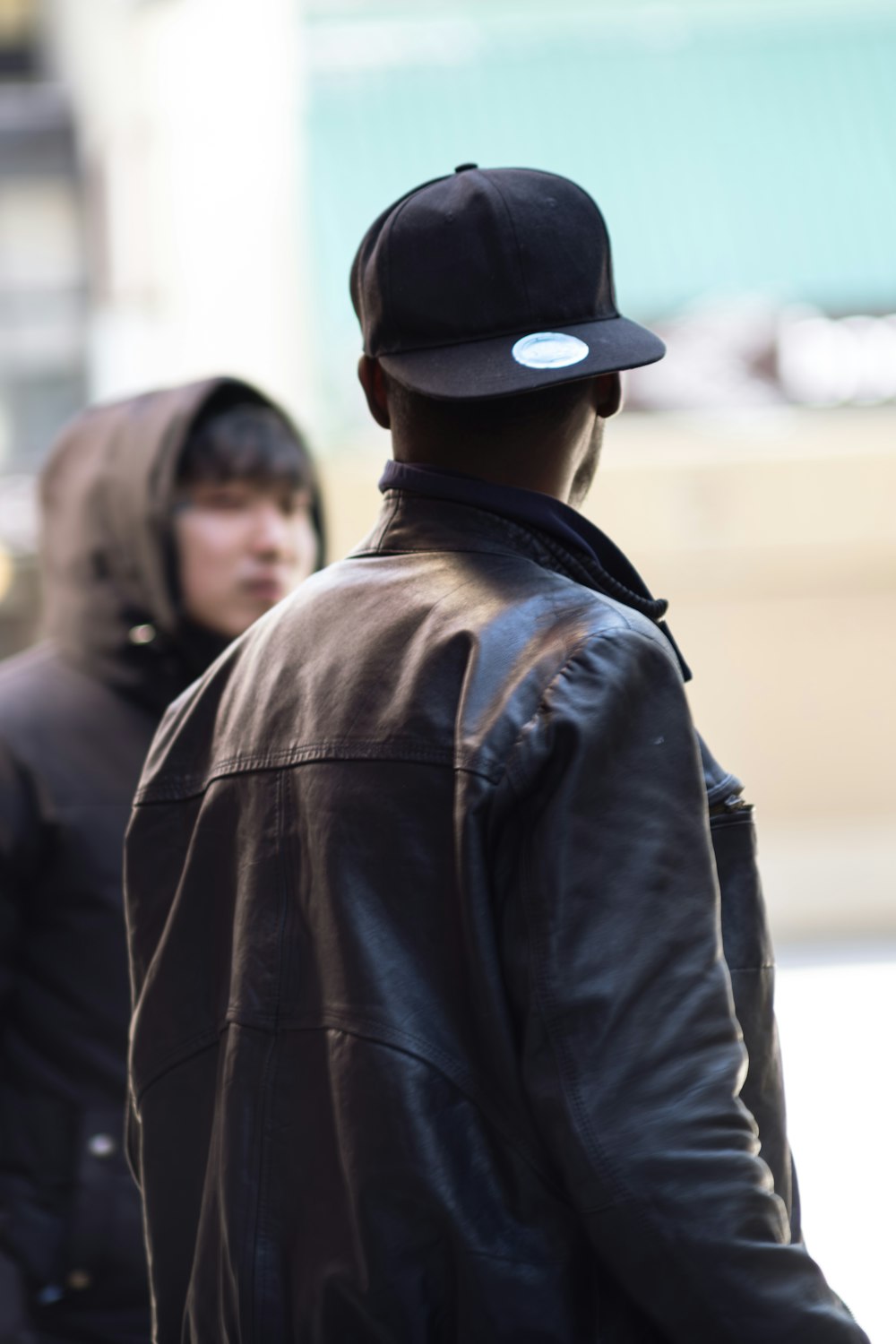 a man in a black jacket and a black hat