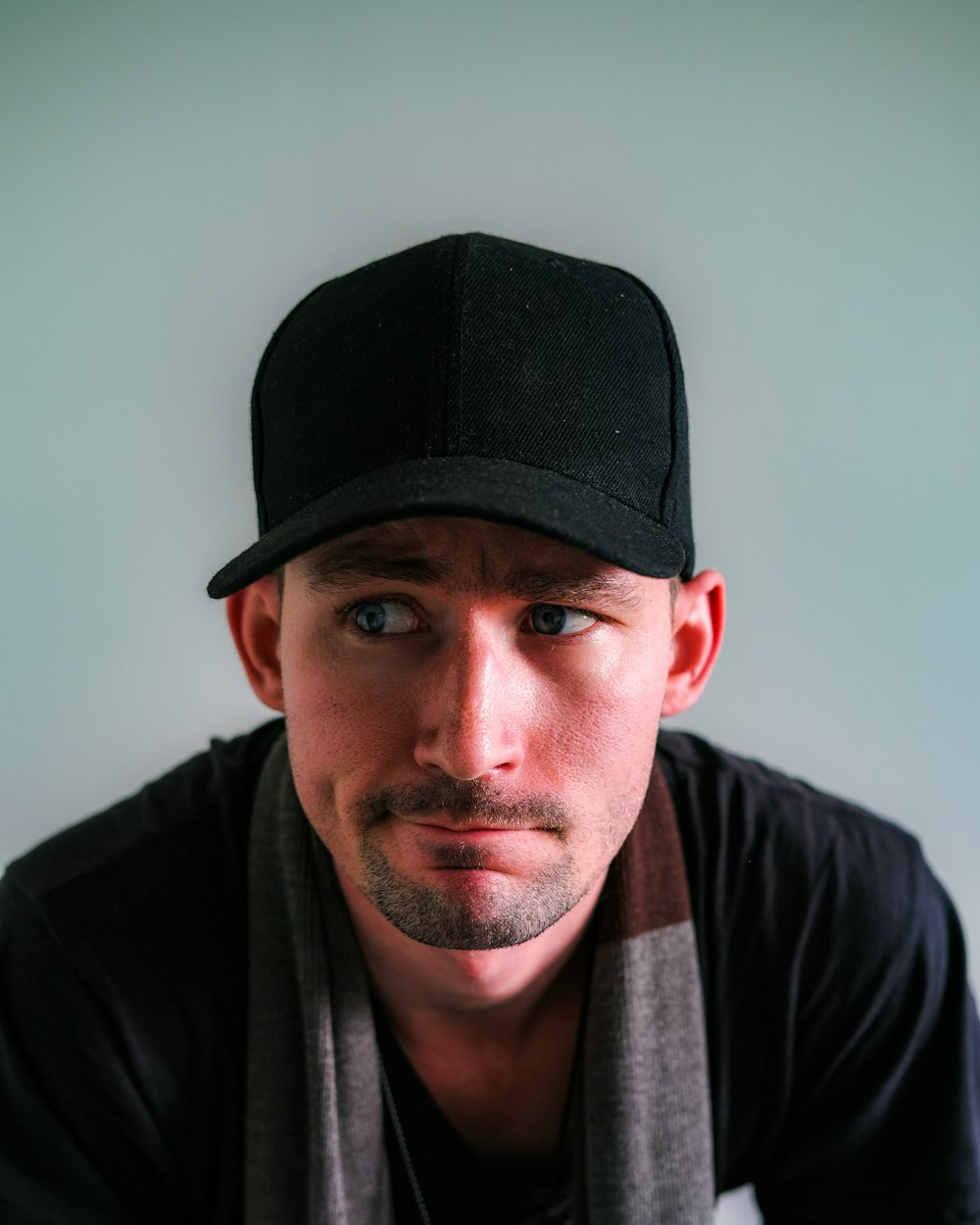 a man wearing a black hat and scarf