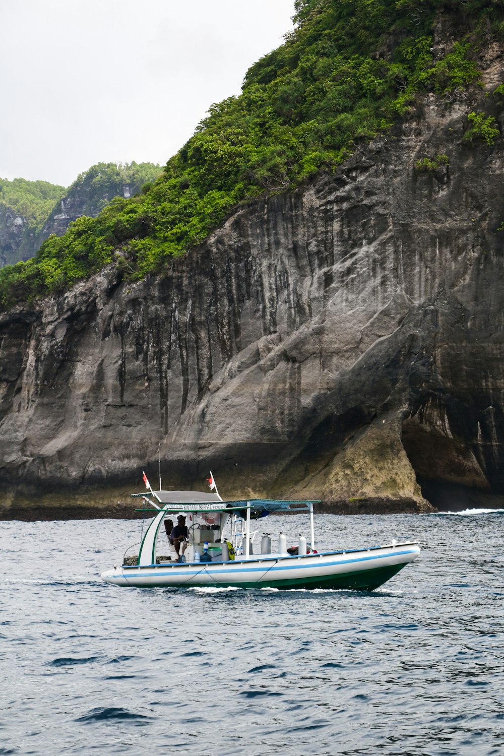 a boat in a body of water near a mountain