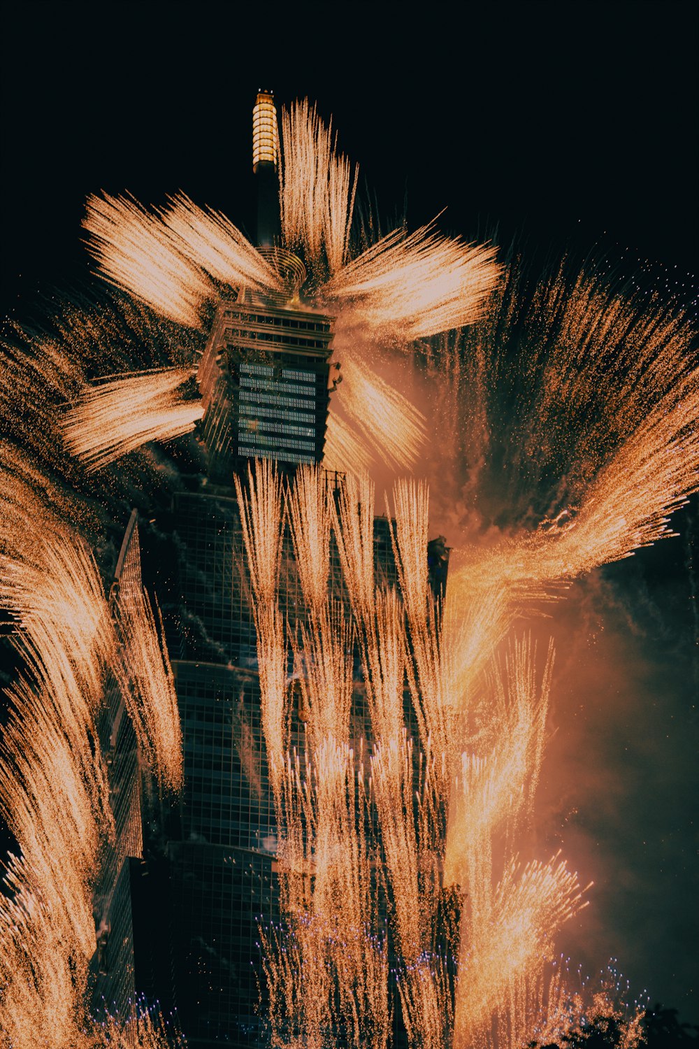 fireworks are lit up in front of a tall building