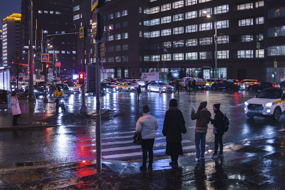 a group of people crossing a street at night