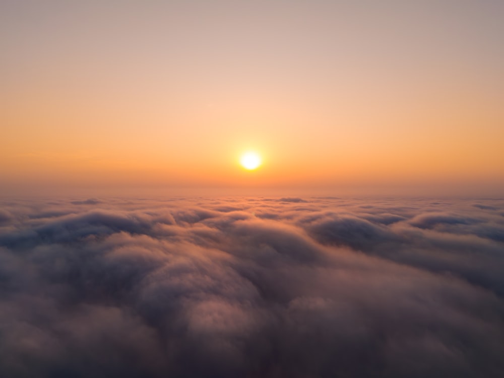 太陽は空の雲の上に沈んでいます