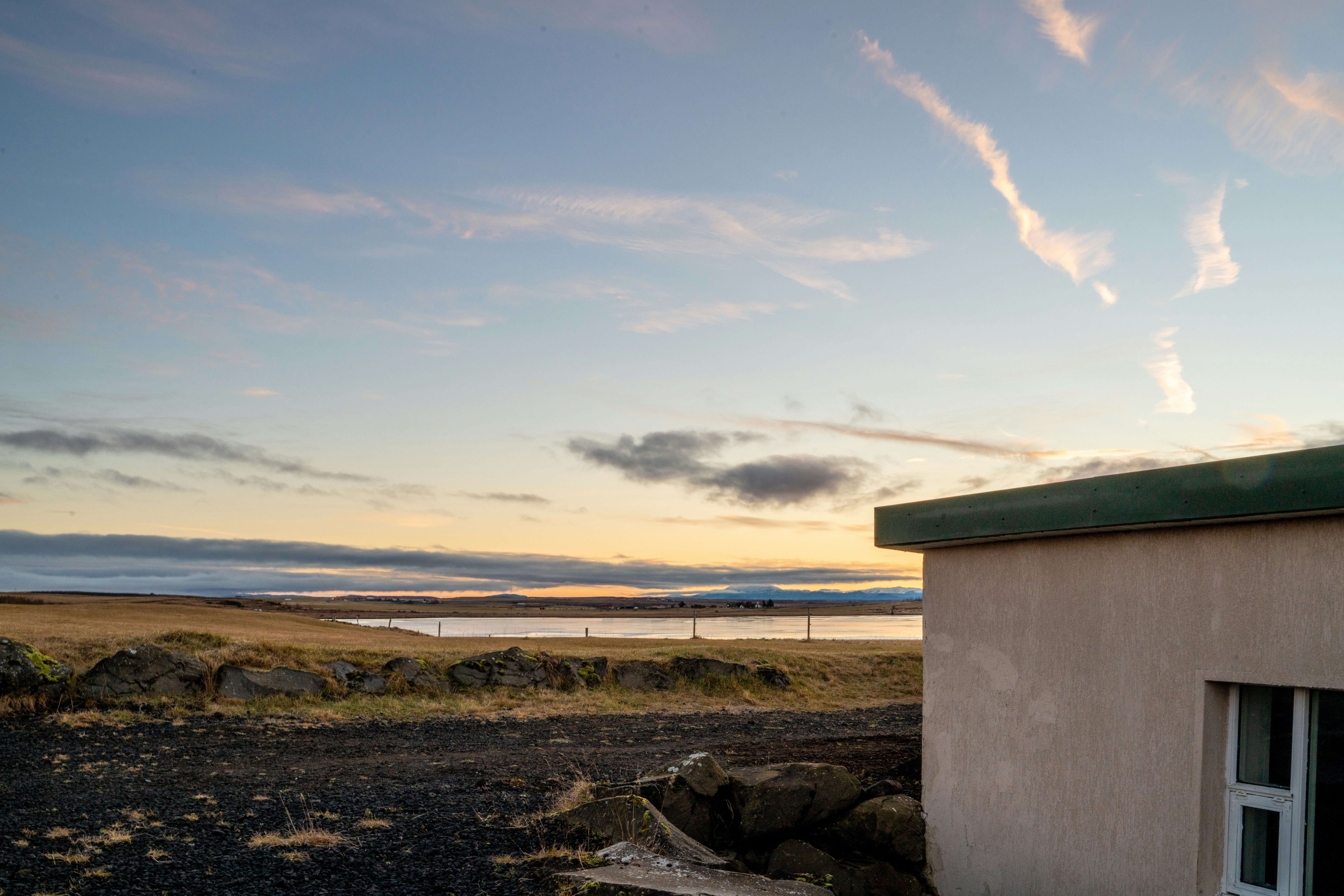 a small building sitting on top of a dry grass field