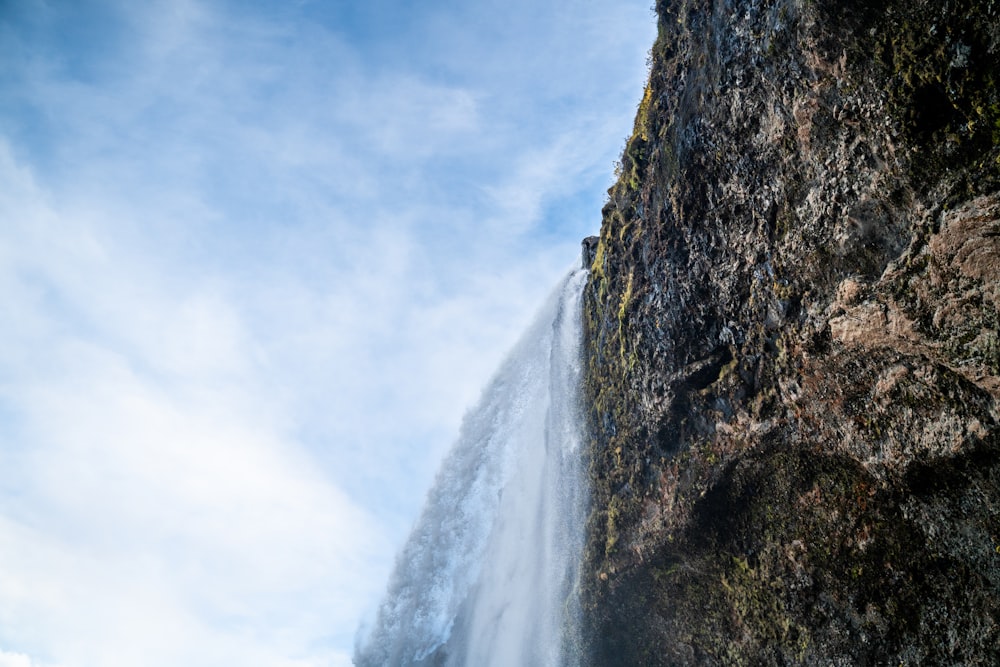a tall waterfall with a blue sky in the background
