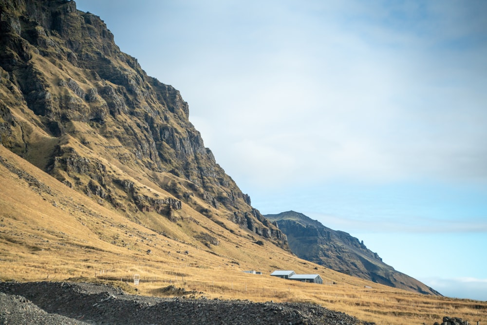 a mountain side with a house in the foreground