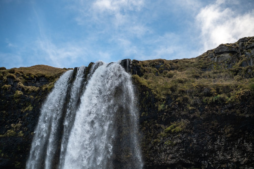 a large waterfall with a blue sky in the background