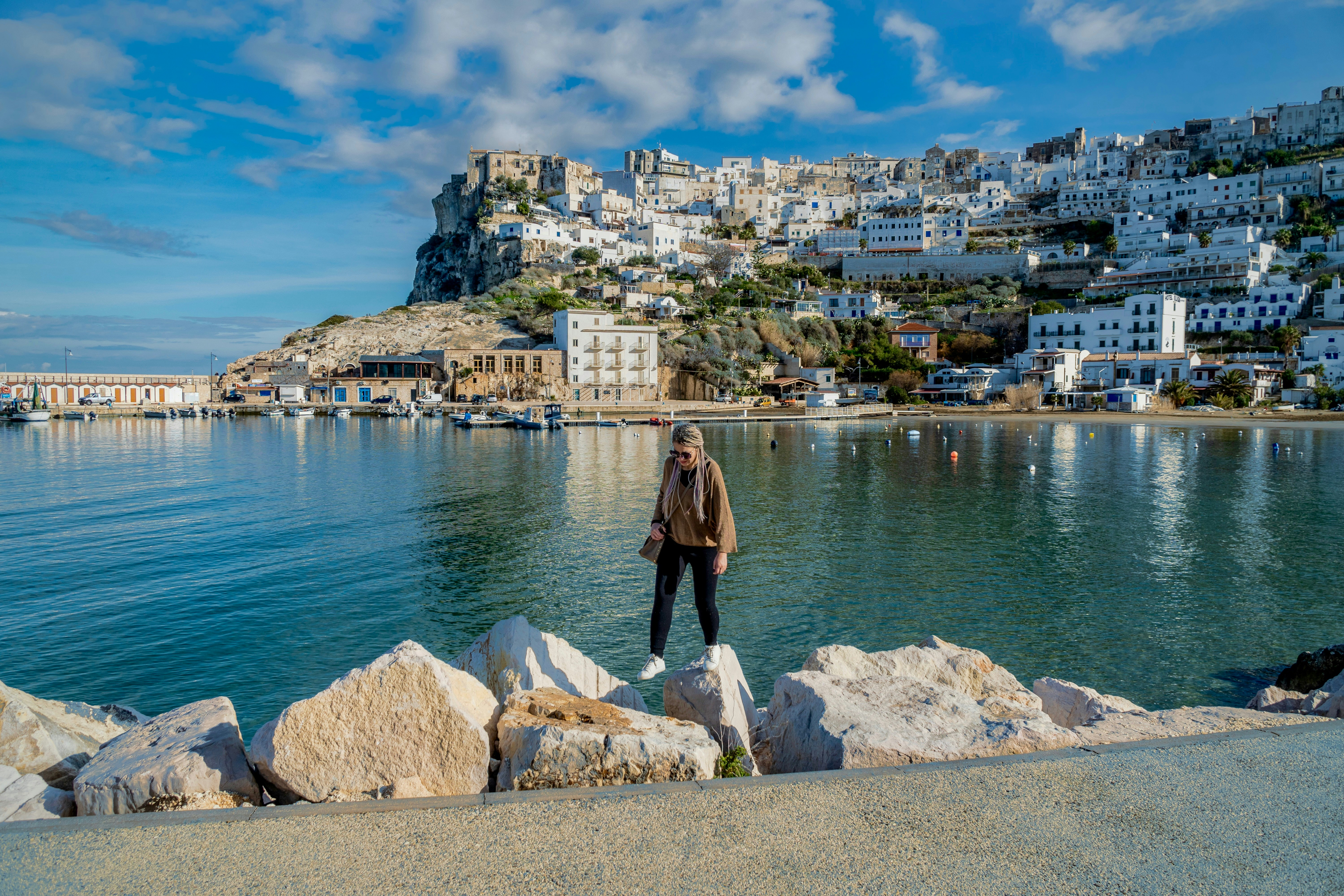 a man standing on a rock next to a body of water