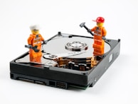 a couple of legos standing next to a hard drive