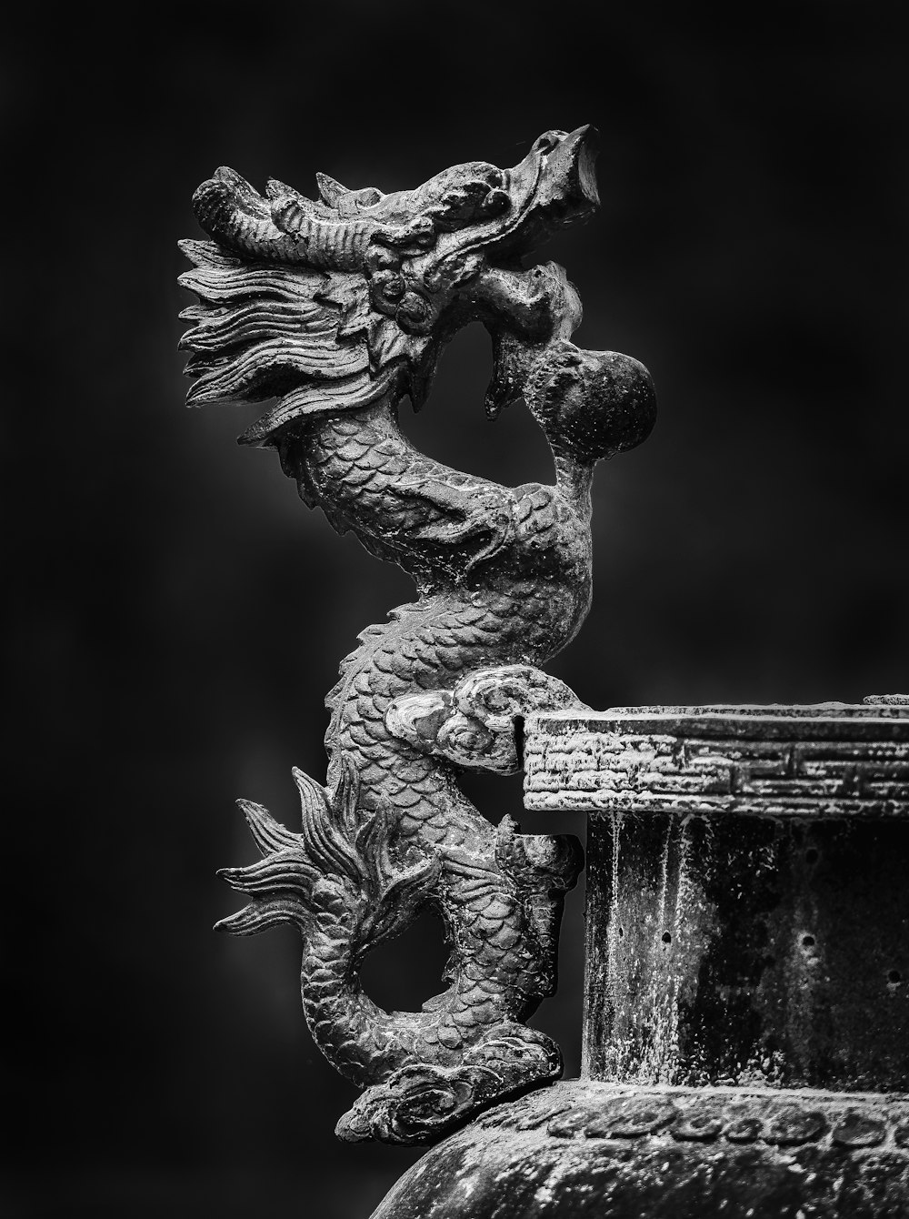 a black and white photo of a dragon statue
