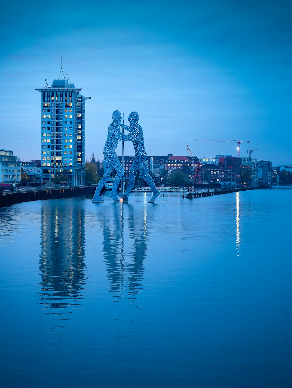a couple of statues sitting on top of a body of water