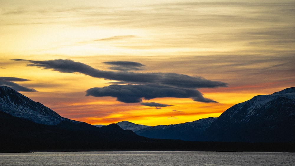 a boat in a body of water with mountains in the background