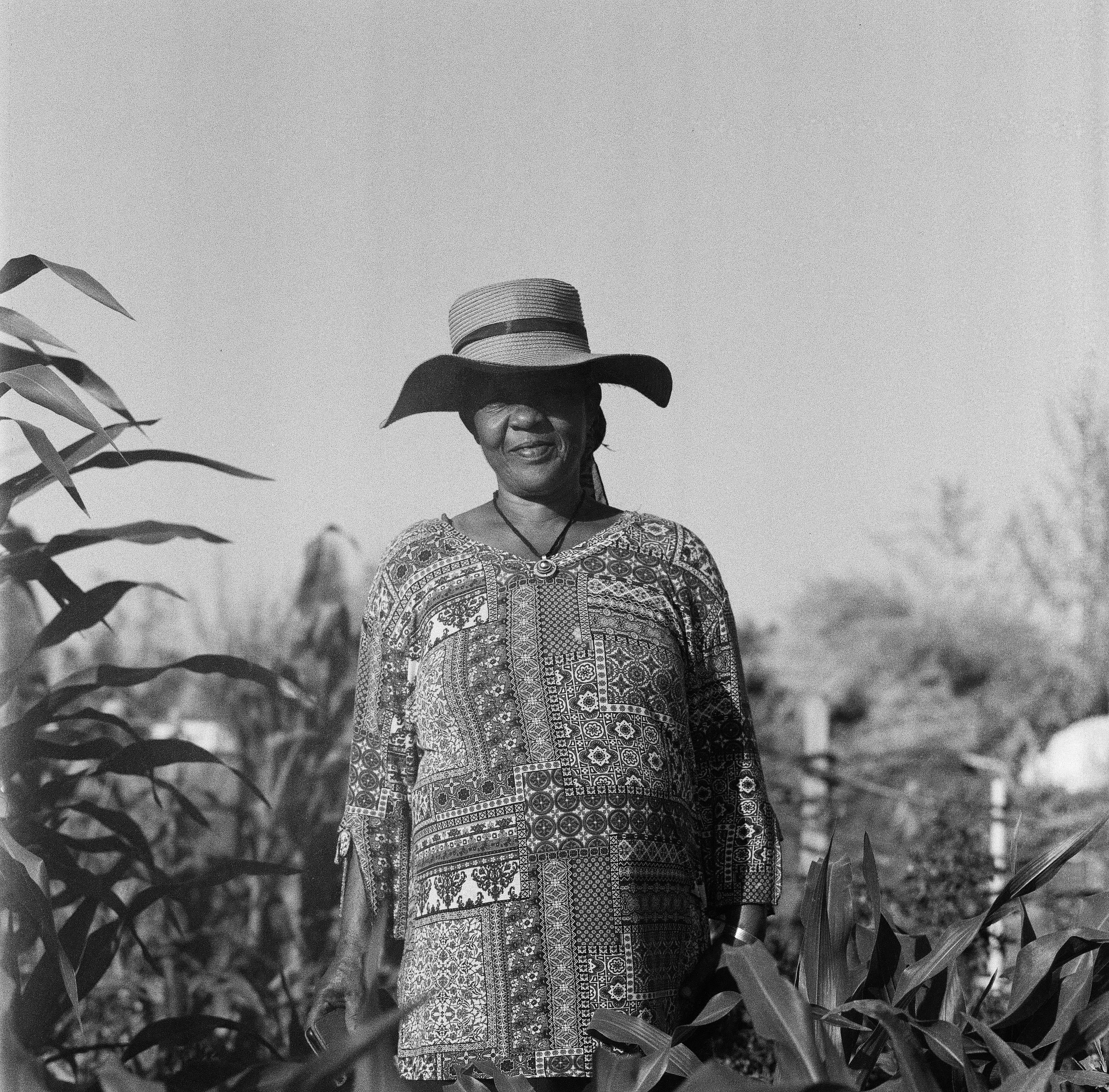 a black and white photo of a person wearing a hat