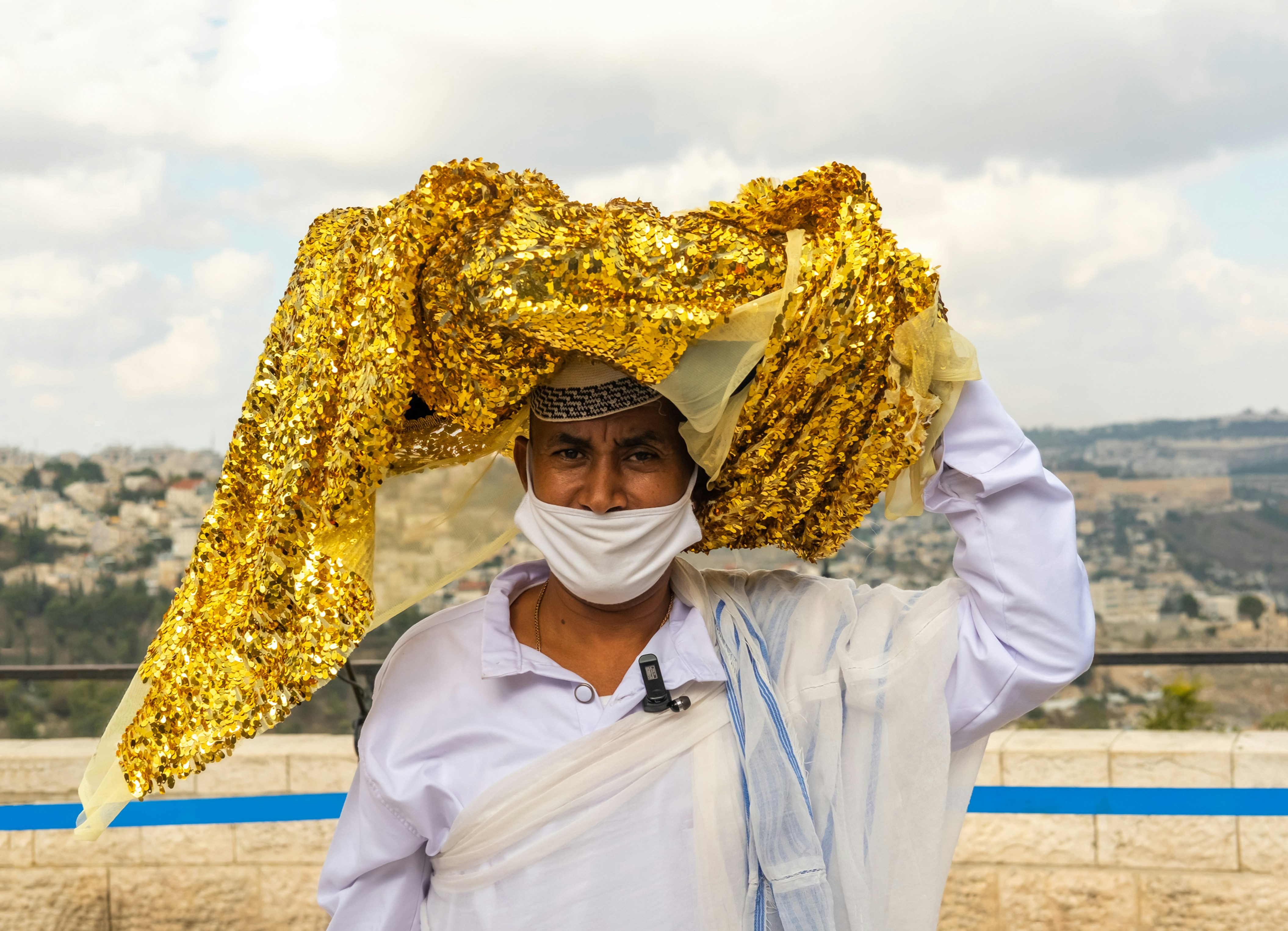 a man in a white shirt and a yellow scarf on his head