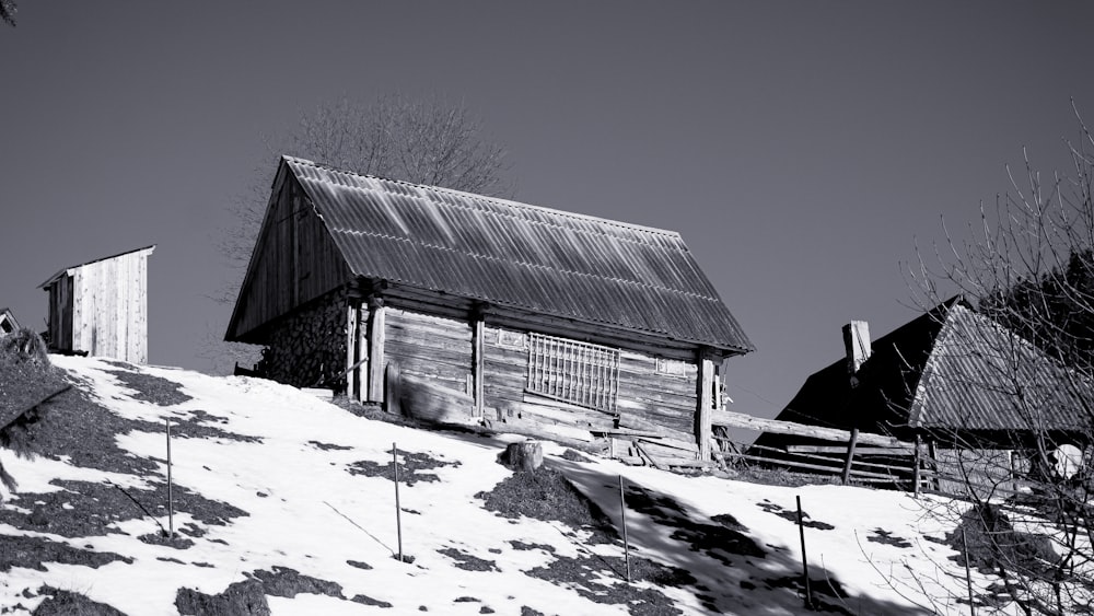 a black and white photo of a house on a snowy hill
