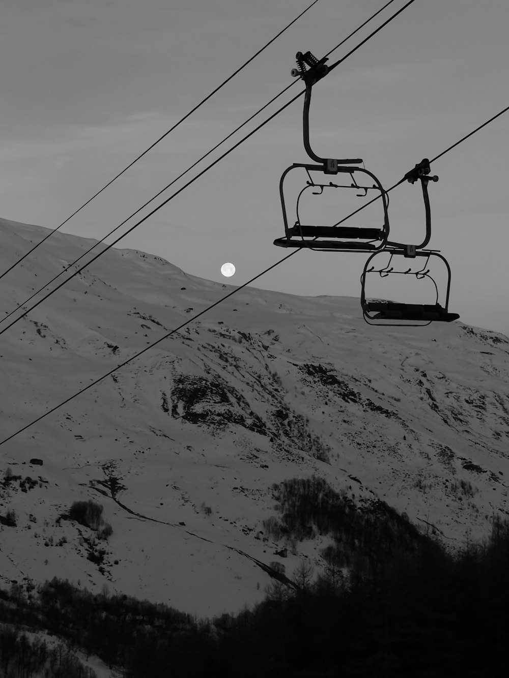 a black and white photo of a ski lift